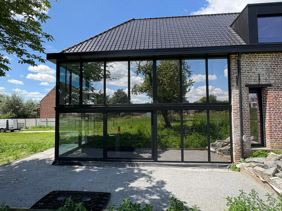 Film solaire teinté posé sur grande baie vitrée — effet miroir extérieur